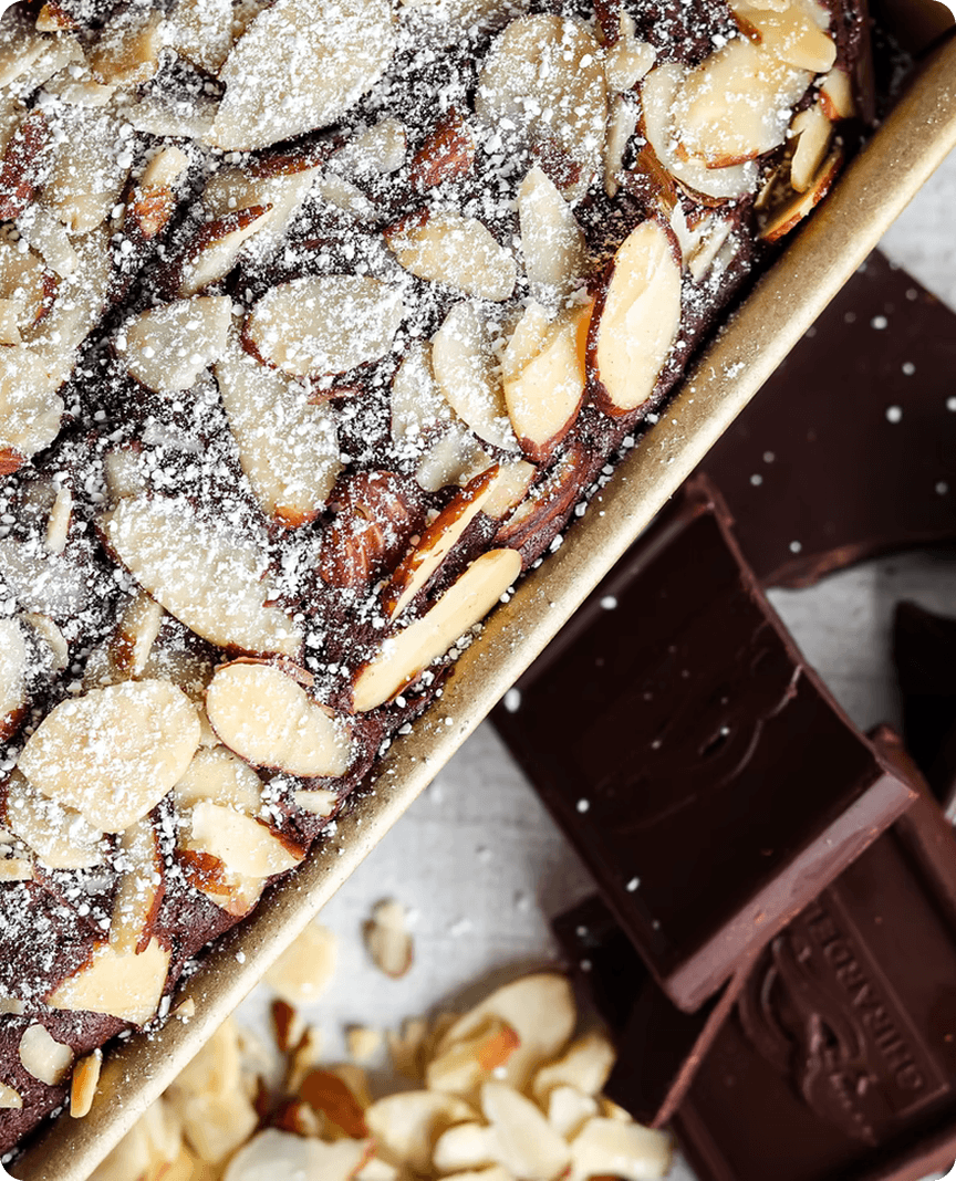 Chocolate cake topped with sliced almonds and powdered sugar