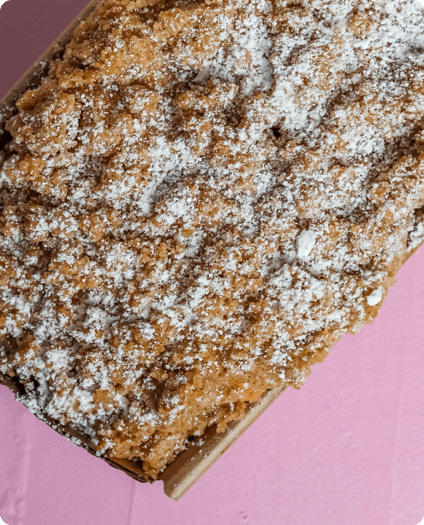Cake topped with powdered sugar on a pink background